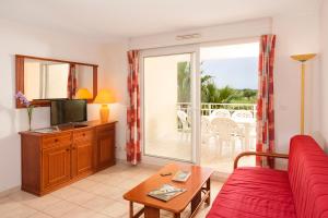 阿格德角Vacancéole - Résidence Le Palmyra Golf的客厅配有红色沙发和电视
