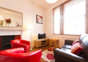 伊斯特布恩Thorne Lodge的客厅配有红色椅子和壁炉