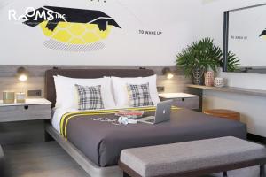 三宝垄Rooms Inc Semarang的一间卧室配有一张带笔记本电脑的床