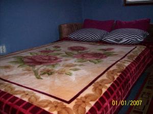 萨拉热窝Pansion Stari Konak的床上有鲜花的毯子