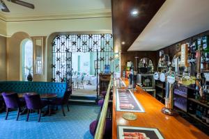 托基The Hotel Balmoral - Adults Only的餐厅内的酒吧,配有紫色的椅子和桌子