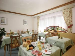 上哈尔默斯巴赫Pension Waldfrieden的一间餐厅配有桌椅,提供食物