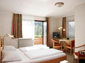 上哈尔默斯巴赫Pension Waldfrieden的酒店客房带两张床和一张桌子,还有一间房间