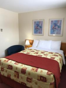 苏圣玛丽主干路汽车旅馆的酒店客房,配有一张带红色毯子的床