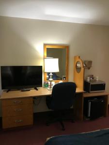 苏圣玛丽主干路汽车旅馆的一张桌子,配有电视和椅子,位于酒店的房间