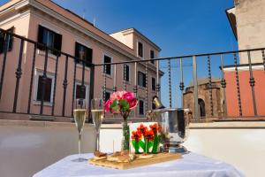 罗马Hotel Balilla的阳台上的桌子上摆放着酒杯和鲜花