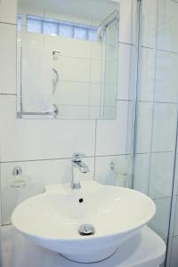 卡梅拉瓦Lofts - Kaunas airport的白色的浴室设有水槽和镜子