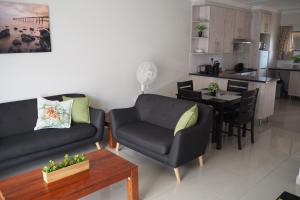 博克斯堡OR Tambo Self Catering Apartments, The Willows的客厅配有沙发、椅子和桌子
