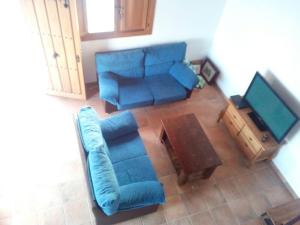 Los BadalejosVilla Almudena的客厅配有蓝色的沙发和电视