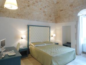 孔韦尔萨诺Parco dei Manieri的一间卧室配有一张床、两张桌子和一张书桌
