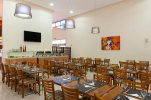 坎皮纳斯Matiz Barão Geraldo Express Hotel的用餐室配有木桌和椅子