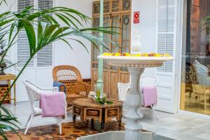 科尔多瓦玛迪娜酒店的一个带桌椅的庭院和一个喷泉
