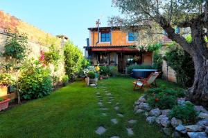 CembranosCanalba Casa Rural的庭院里带长凳和树的花园
