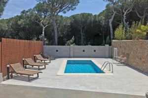 莱斯卡拉Casa Bel Coll的庭院设有游泳池、椅子和围栏