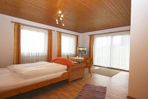 里姆斯廷格Gästehaus Annemarie的卧室配有床、桌子和窗户。