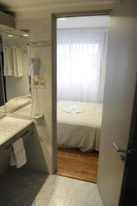 蒙得维的亚加利福尼亚酒店的浴室设有1张床和带镜子的淋浴