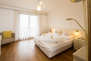 拉古多安德林德旅馆的卧室配有一张白色大床和镜子