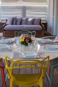古斯塔维亚Penthouse de Luxe Gustavia的一张桌子,上面摆放着黄色椅子和一张鲜花桌