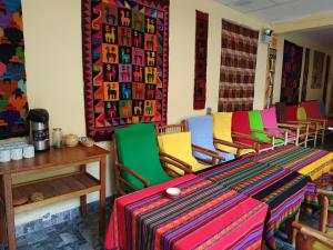 皮萨克Hospedaje Inti的一间设有五颜六色椅子和桌子的房间