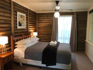 格罗夫海洋钛树度假村的一间卧室配有一张带木墙和窗户的床。