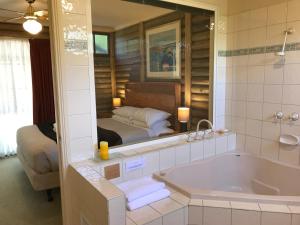 格罗夫海洋钛树度假村的带浴缸的浴室和1间带1张床的卧室