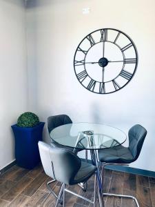 阿瓜迪亚Modern Suite #2 Pasavento的桌子和椅子以及墙上的时钟