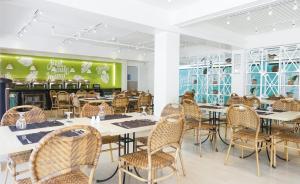 长滩岛帕缇欧太平洋度假村的一间带桌椅和绿色墙壁的用餐室