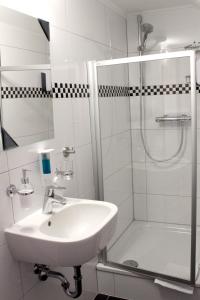 梅尔斯堡维多莉亚酒店的白色的浴室设有水槽和淋浴。