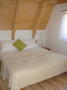 新锡德勒湖畔普巴赫Ferienhäuser Finiki的一张位于带木制天花板的客房内的大床