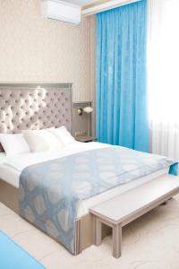 托木斯克Old Town的一间卧室配有一张带蓝色窗帘的大床