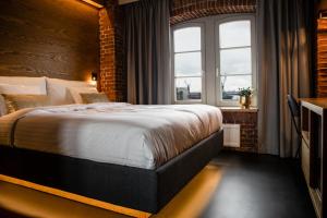 汉堡GINN Hotel Hamburg Elbspeicher的一间卧室设有一张带砖墙的大床