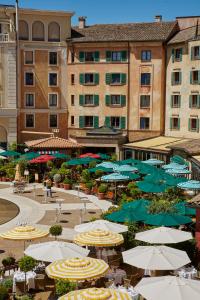 鲁斯特欧罗巴游乐园和厄尔布尼斯度假四星级高级酒店的一大群伞,桌子和建筑物