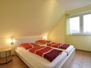 齐罗Spacious Holiday Home in Zierow near Sea的一间卧室配有一张带橙色枕头的大床