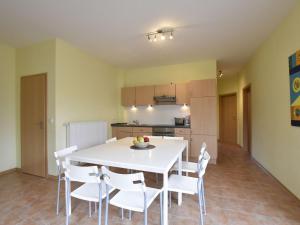 齐罗Relaxed Apartment in Puerto del Carmen with Swimming Pool的厨房以及带白色桌椅的用餐室。
