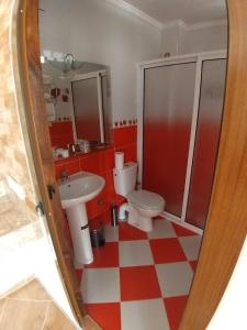 丹吉尔TANJITAN HOSPITALITE的浴室设有2个卫生间,铺有红色和白色的格子地板。