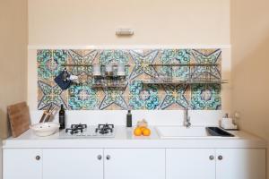 莫迪卡Jasmine Modica Luxury House的厨房设有水槽和瓷砖墙