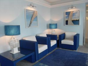布里萨戈Holiday Hotel YACHTSPORT RESORT Lago Maggiore的蓝色的客厅配有两把椅子和一张桌子