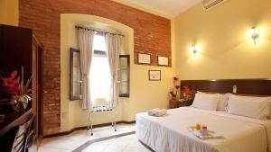 萨尔瓦多索尔卡尔穆套房公寓的一间卧室设有一张大床和一个窗户。