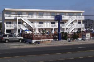 布兰特海滩海马汽车旅馆的一座带白色阳台的建筑,前面有一个停车位