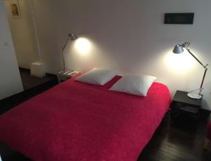巴黎安妮勒特博加酒店的一间卧室配有红色的床和2个白色枕头