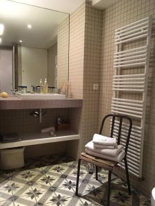巴黎安妮勒特博加酒店的浴室设有椅子、水槽和镜子