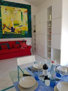 马西亚娜马里纳Villino I Sugheri的客厅配有红色的沙发和带玻璃杯的桌子