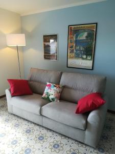 蒙特罗索阿尔马雷Costamare的客厅的沙发,配有红色枕头
