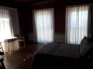 阿维拉穆拉亚斯酒店的卧室配有白色窗帘、床和桌子