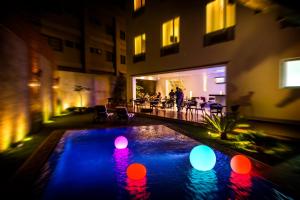 马那瓜元素精品酒店 的夜晚在庭院里有一个灯光缤纷的游泳池