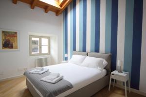 韦尔巴尼亚Verbania - Luxury Italy Apartments的一间卧室配有一张蓝色和白色条纹的床