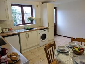 特尔福德Princes Lodge的厨房配有桌子和洗衣机。