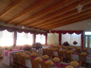马卡尔斯卡Pansion Komfor Moča的宴会厅配有桌椅和窗户