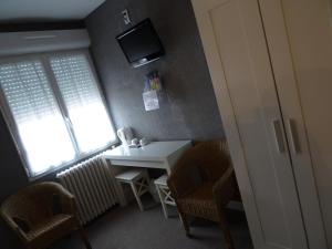 Alban热烈欢迎酒店的小房间设有一张桌子和一台墙上的电视