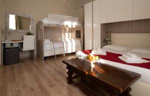 皮昂比诺Antico Hotel Moderno的一间卧室配有一张床、一张桌子和一张双层床。